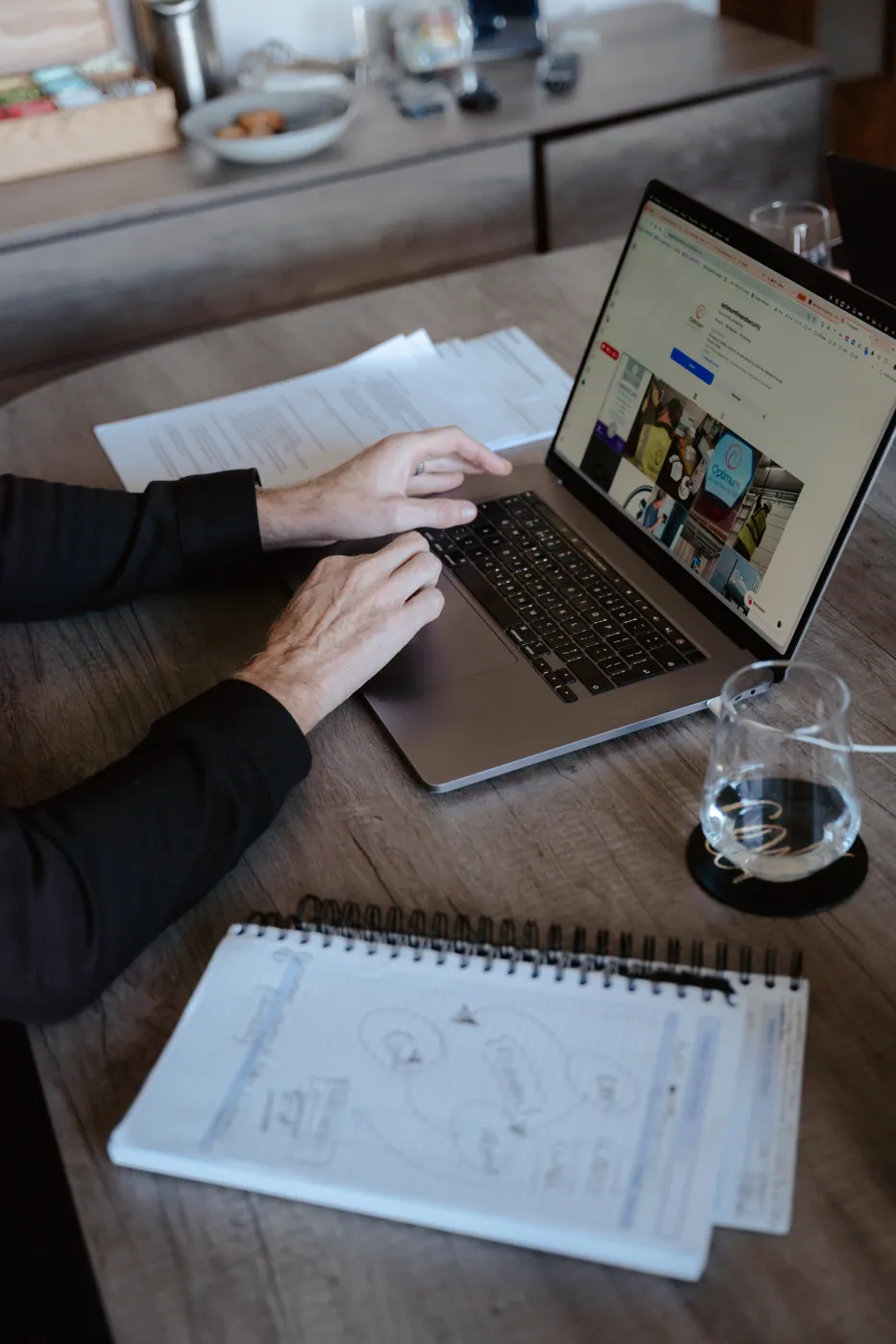 Working through a plan on a laptop, notebook alongside