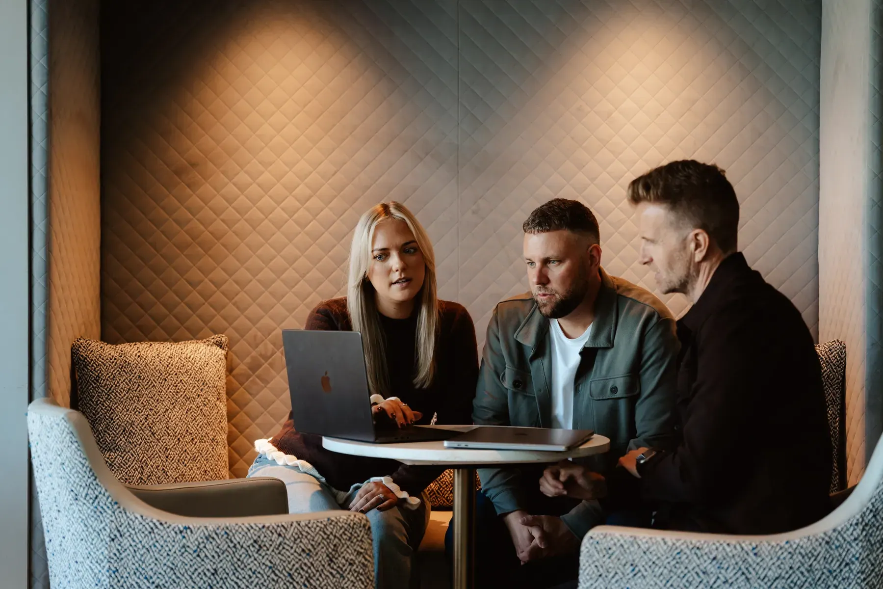 Emma, Rikki and Mark working together in a lounge booth