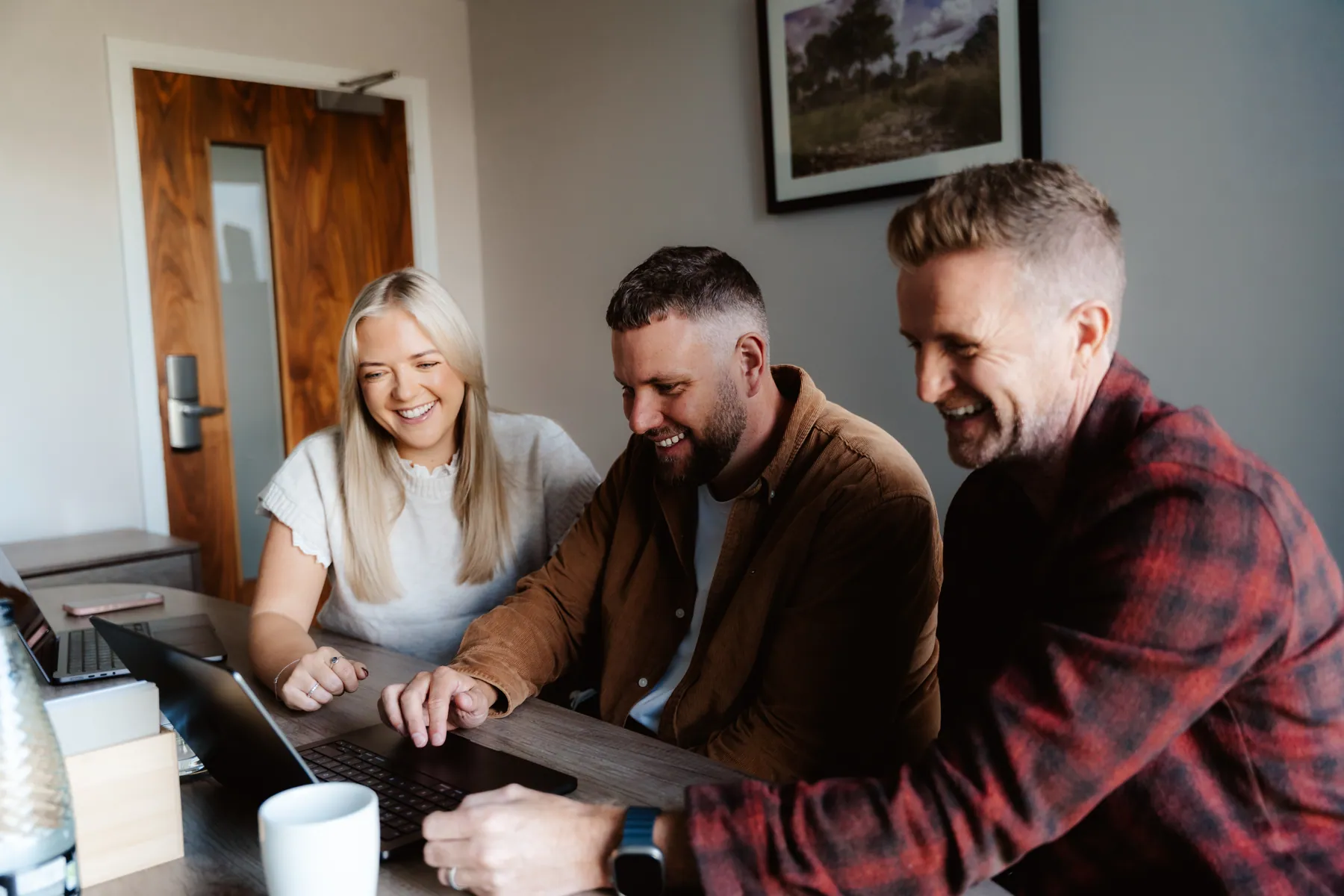 Emma, Rikki and Mark laughing over a laptop