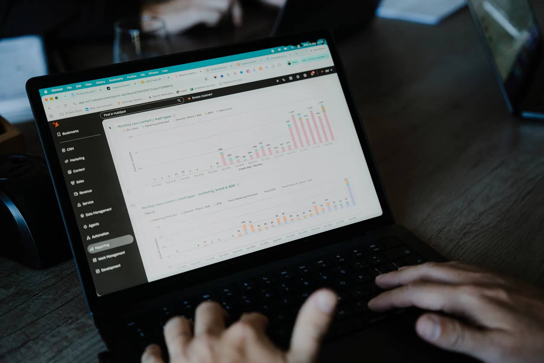 Typing beside a chart on a laptop
