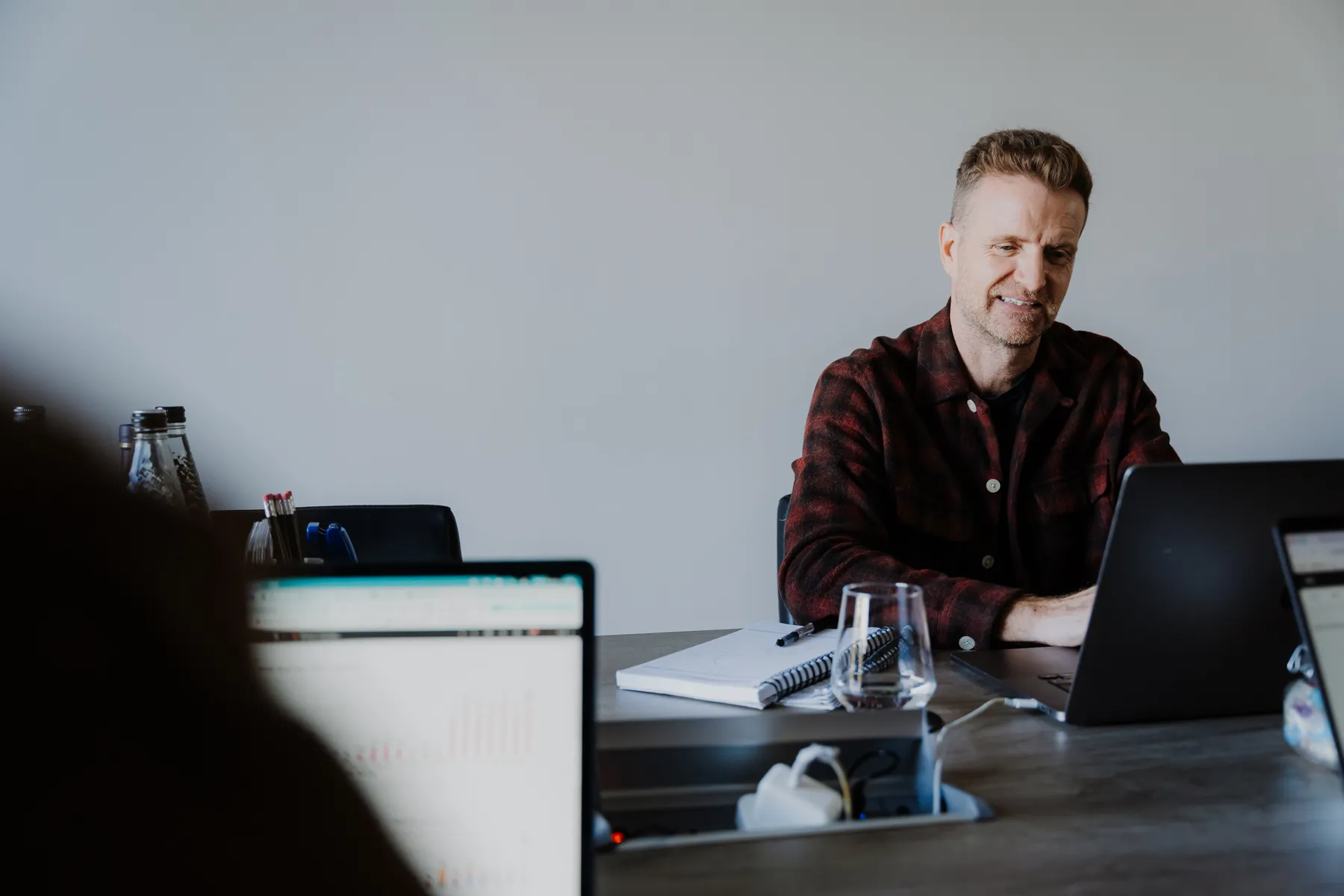 Mark at the meeting table with a report on screen