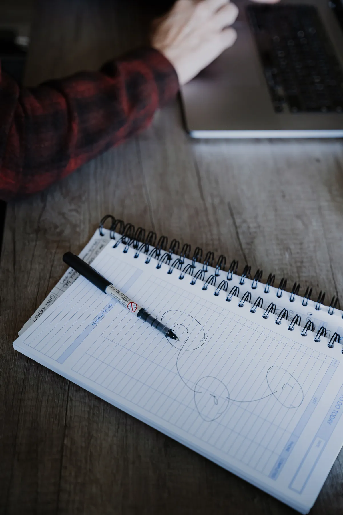 A spiral notebook of plans on the table